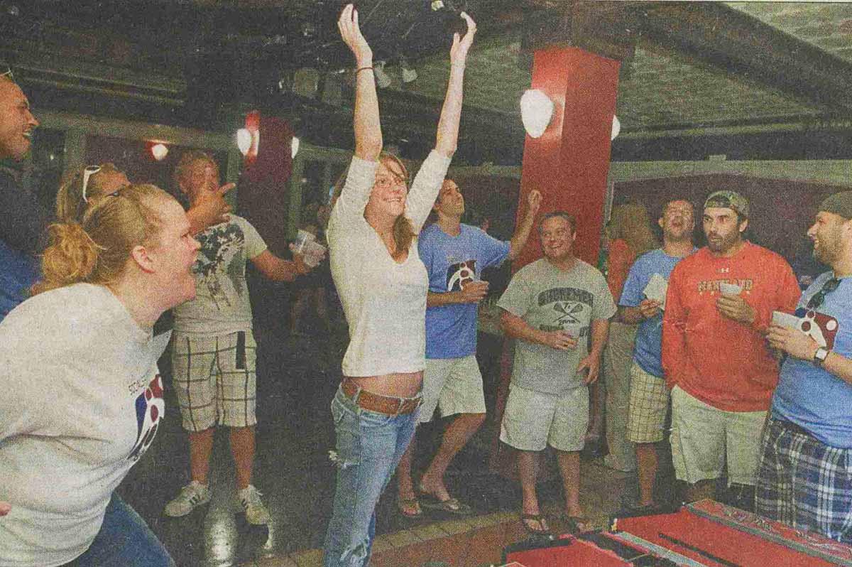 Meredith Harvill of Bethesda (center) celebrates a good score with her teammates during Skee-Ball league (Story reprint and Photo courtesy of The Gazette)